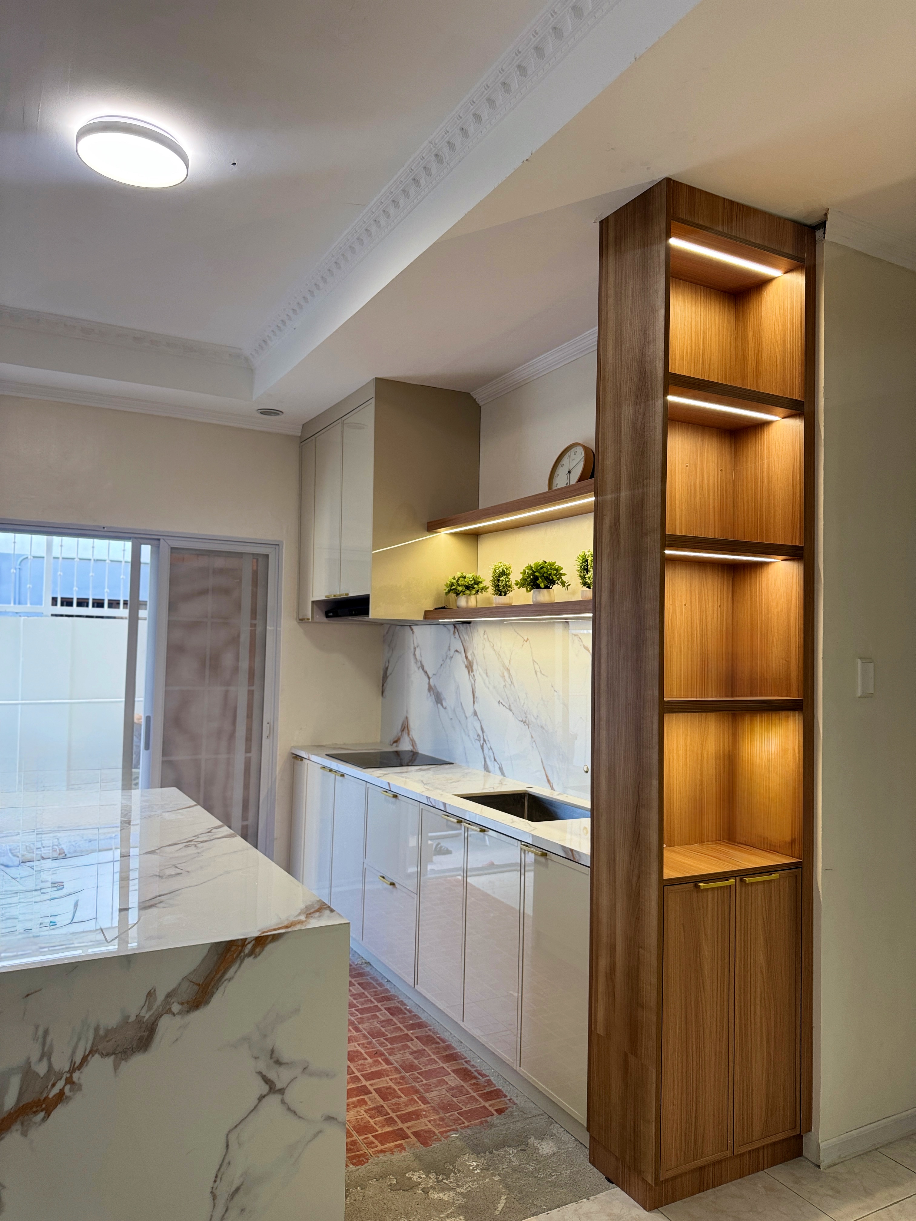 Wide kitchen view with marble island and walnut display shelving