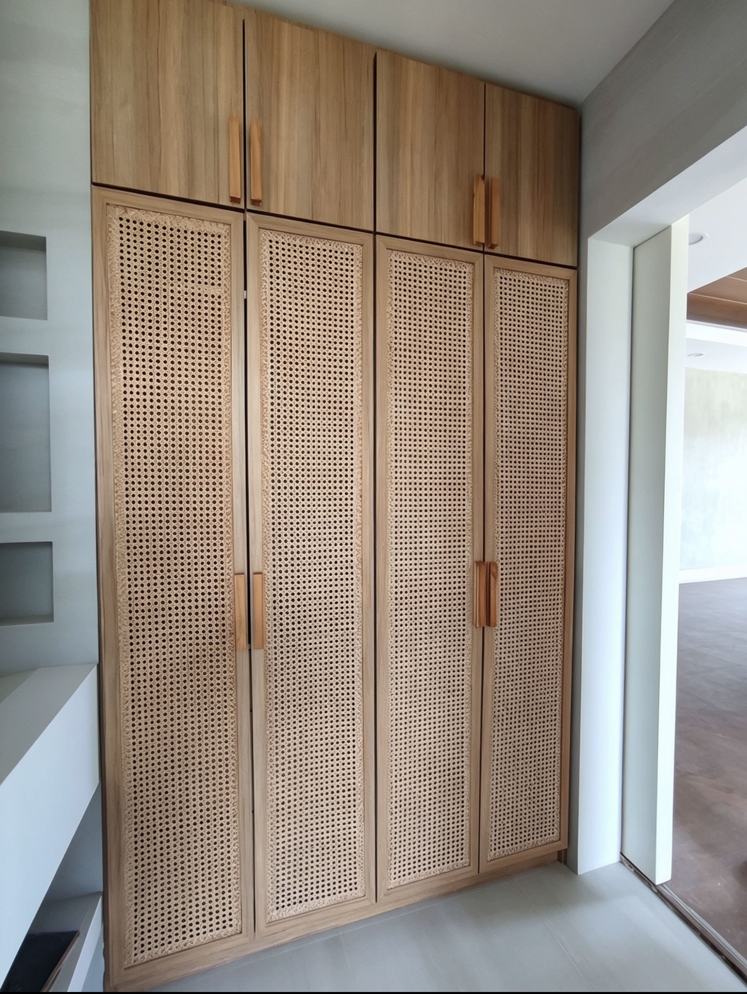 Built-in wardrobe with rattan door panels and wood grain finish