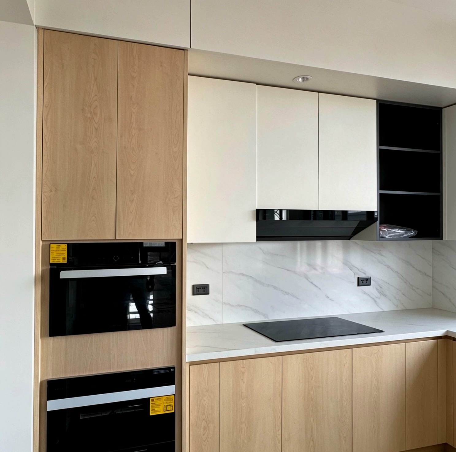 Cream and wood kitchen with marble backsplash and built-in oven tower
